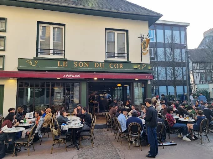 La façade et la terrasse pleine à la tombée du jour, rue Eau-de-Robec.