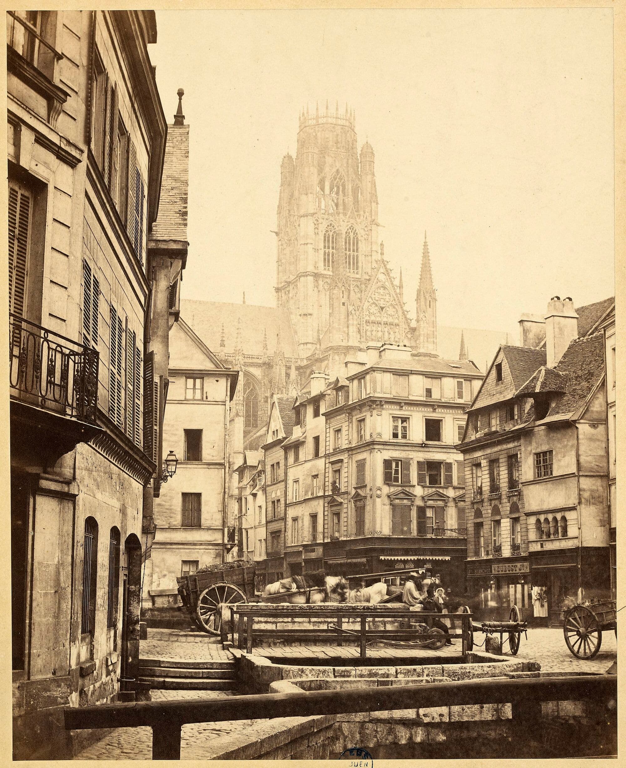 La place de l'Eau-de-Robec vers 1870 : le ruisseau à ciel ouvert, le pavé, et les séchoirs à draps qui sortent des toits.