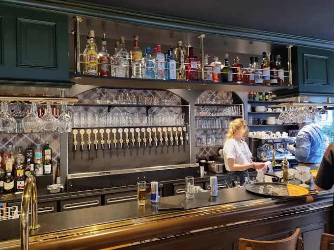 Le comptoir en service, l'étagère de spiritueux et la rangée de becs.